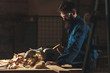 © Marko Milanovic/Stocksy - Carpenters working in workshop/sawmil with wood on circular saw.