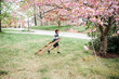© Lea Jones/Stocksy - little boy climbing a tree with pink blossoms