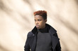 © Fjello/Stocksy - Young black man standing against a brown wall.