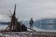 © Tari Gunstone/Stocksy - Woman standing on driftwood sculpture/fort