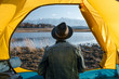 © Alexandr Ivanets/Stocksy - Back view of tourist in tent