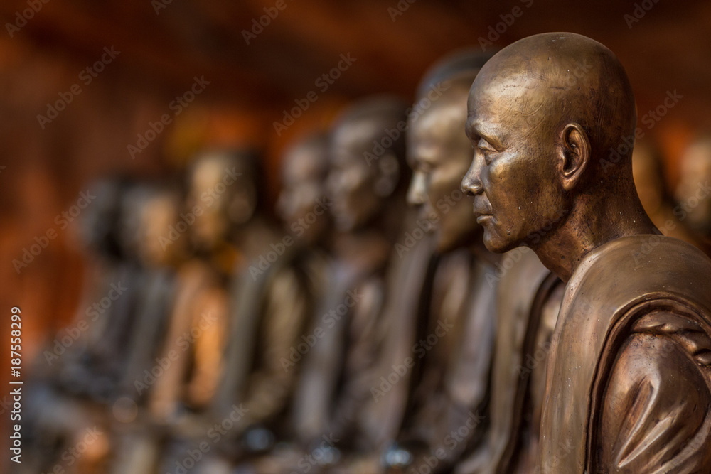 Buddhist monks statues symbol of peace and serenity at Wat Phu Tok temple, Thailand, ascetism and meditation, buddhist art work - obrazy, fototapety, plakaty 