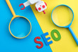 SEO Search engine optimization concept with blue and yellow magnifying glass, alphabet abbreviation SEO and robot on colorful background