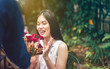 © Fluky - Asian girls are delighted with the red flowers received from the man she loved.