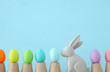 © tomertu - Cute bunny next to easter colorful eggs over colorful background.