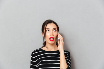 Wall Mural - Portrait of a surprised woman talking on mobile phone