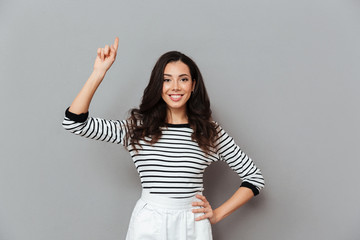 Poster - Portrait of a smiling woman pointing finger up