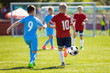 © matimix - Running Soccer Football Players. Footballers Kicking Football Match. Soccer School Tournament. Young Soccer Players Running After the Ball. Soccer Stadium in the Background