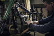 © Connect Images - Mechanic repairing vintage motorcycle engine in workshop