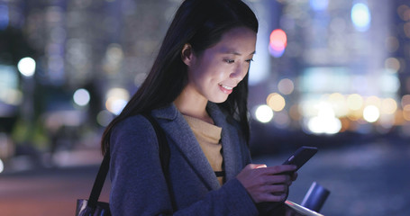 Wall Mural - Asian Woman use of smart phone in city at night