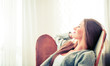 © leszekglasner - Woman at home sitting on modern chair near window relaxing in living room