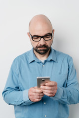 Wall Mural - Portrait of serious man sending messages on mobile