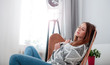 © leszekglasner - Woman at home sitting on modern chair near window relaxing in living room