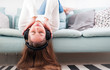 © leszekglasner - Woman with headphones on sofa at home listening music