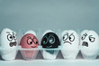Faces on eggs in the form of facial expressions, reflecting emotions. The concept of racism, misunderstanding, a barrier in relations, denial of society. Barriers between people, prejudice.