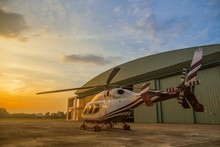 Silhouette Of Helicopter In The Parking Lot Or Runway With Sunrise Background,twilight Helicopter On The Helipad