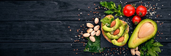 Sandwich with avocados and almonds. On a wooden background. Top view. Free space for your text.