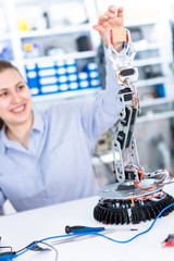 Wall Mural - A girl in a University laboratory is experimenting with a robot