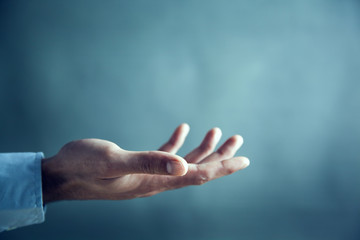 male is standing and shows outstretched hand with open palm