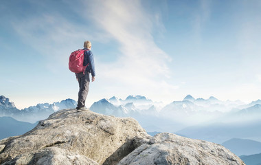 Wall Mural - tourist on the peak of high rocks. sport and active life concept.