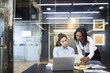 © Cavan Images - Businesswomen discussing paperwork at conference table in board room