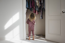 Rear View Of Girl Standing At Closet