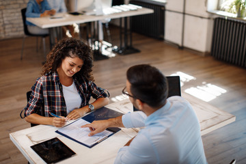 young woman signing contract with manager