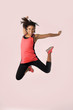 © Wordley Calvo Stock - young happy and beautiful girl jumping crazy excited in female sport fitness concept isolated on pink background wearing red sportswear
