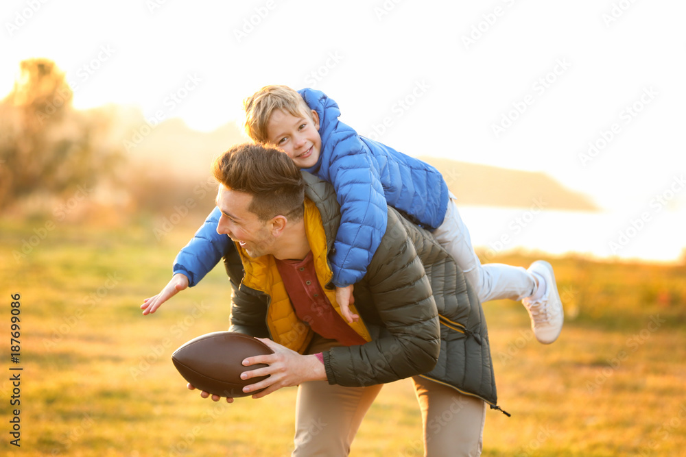 Father with little son playing rugby outdoors Stock Photo | Adobe Stock