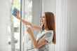 © Africa Studio - Beautiful woman cleaning window at home