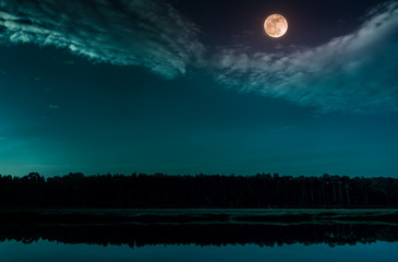 Emerald green sky and full moon at seaboard. Serenity nature background.