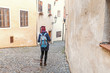 © EdNurg - Woman tourist in a coat with a backpack travels in the old streets of Cesky Krumlov