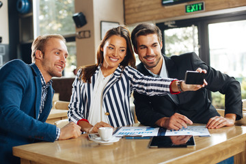 Wall Mural - Young business people making selfie in a cafe