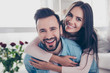 © deagreez - Close up photo of cheerful excited glad careless happy with toothy beaming smile brunette attractive woman and with stylish hairdo man, she is hugging him from the back