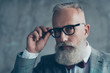 © deagreez - Close up portrait of elegant rich confident smart with modern hairdress haircut white beard creative virile dreamy luxurious pensive freelancer touching black rim-glasses isolated on grey background