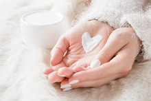 Beautiful Groomed Woman's Hands With Cream Jar On The Fluffy Blanket. Moisturizing Cream For Clean And Soft Skin In Winter Time. Heart Shape Created From Cream. Love A Body. Healthcare Concept.