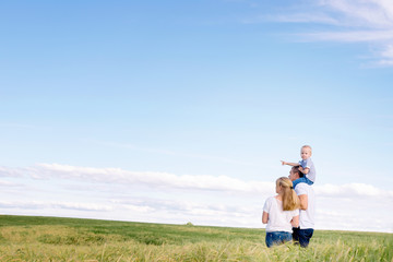 Wall Mural - the happy family walks across the field