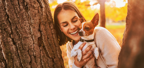 Portrait of young happy woman holding little cute dog