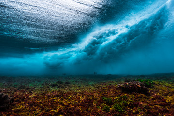 underwater view of the surf spot with wave breaking over coral reef