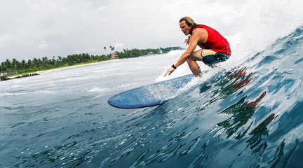 Wall Mural - Young surfer rides the ocean wave