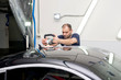 © zhekkka - A man polishes a black car with a polisher