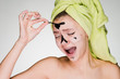 © mnelen.com - A young girl with a towel on her head with pain relieves a black mask from herself