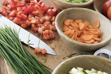 Wall Mural - Chopped tomatoes, carrots, and chives on cutting board with knife surrounded by other ingredients.