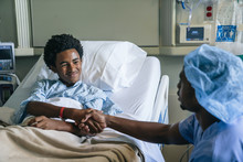 Nurse Shaking Hands With Boy In Hospital Bed