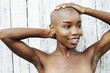 © Peathegee Inc/Blend Images - Close up of naked black woman rubbing bald head