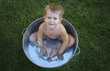 © Valeriya Tikhonova/Blend Images - Naked Caucasian boy in metal tub in grass
