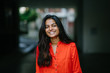 © Danon - Portrait of attractive and young Indian woman smiling in an orange ethnic dress during the day