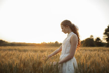 Caucasian Girl Standing In Field Of Wheat