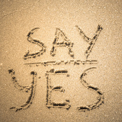 Wall Mural - Say Yes word is written on the beach sand