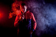 © Виталий Сова - Man in sport hoody vaping an electronic cigarette.Isolated on black background.Around  clouds of smoke